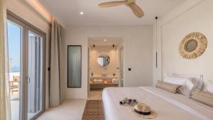 a bedroom with a large white bed and a mirror at Nove Milos Luxury by Estia in Pollonia