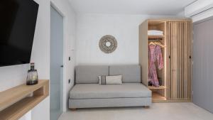 Una silla gris en una habitación con armario en Nove Milos Luxury by Estia en Pollonia