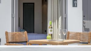 a table with a bottle of wine and two glasses at Nove Milos Luxury by Estia in Pollonia