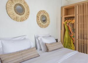 a bedroom with white pillows and mirrors on the wall at Nove Milos Luxury by Estia in Pollonia