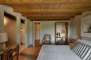 - une chambre avec un lit et un plafond en bois dans l'établissement Corte Massimago, à Mezzane di Sotto