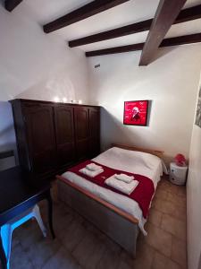 ein kleines Schlafzimmer mit einem Bett und einem Schreibtisch in der Unterkunft Aile de villa climatisée avec piscine in Porticcio