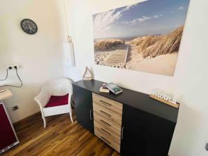 - un bureau avec une chaise et une photo de la plage dans l'établissement Nordsee Appartement in Hagen, à Hagen
