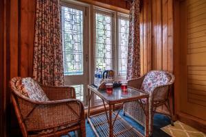 a room with two chairs and a table and a window at Hotel Little Silver in Pahalgām