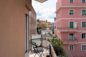 uma varanda com cadeiras e um edifício cor-de-rosa em Nel cuore di Monteverde em Roma