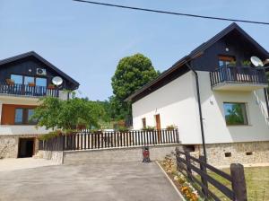 a house with a black and white at Farma & Apartmani OPG Sasa Delic in Korenica