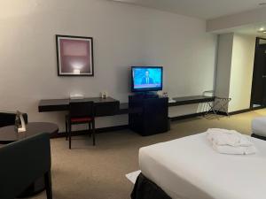 a hotel room with a bed and a television at Al Jazira Club Hotel in Abu Dhabi