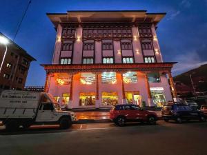 un gran edificio con coches estacionados frente a él en Tshongdu Boutique en Paro