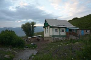 uma pequena casa sentada no topo de uma colina em Ak-Kaiyn Summer Rest Place em Kaindy
