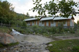 uma casa com um rio em frente em Ak-Kaiyn Summer Rest Place em Kaindy