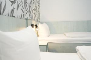 a small room with two beds and a mirror at Hotel Attaché an der Messe in Frankfurt/Main