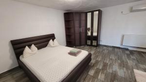 a bedroom with a bed with a book on it at Casa Cristina Corbu in Corbu