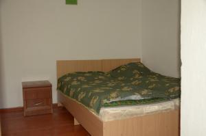 uma cama com uma estrutura de madeira e uma mesa de cabeceira em Ak-Kaiyn Summer Rest Place em Kaindy