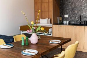 a dining room table with a vase of flowers on it at Hotel Kitchen59 in Sofia