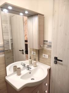 uma casa de banho com um lavatório branco e um espelho. em La Torre em Tarquinia