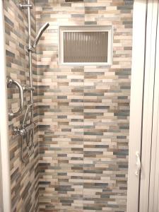 uma casa de banho com um chuveiro e uma parede de azulejos em La Torre em Tarquinia