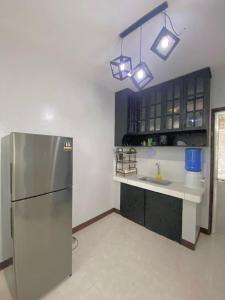 uma cozinha com um frigorífico de aço inoxidável e luzes em AB Yam Staycation Gensan near Venue88 em General Santos