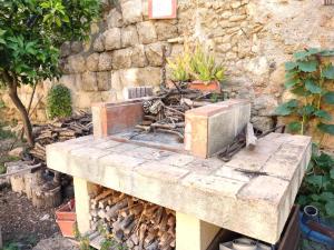 a stone wall with a stone table with a stove at La Torre in Tarquinia