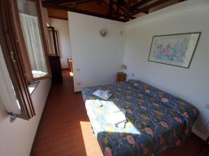 a small bedroom with a bed and a window at Podere S.Giulia - casale S.Giulia in Riotorto