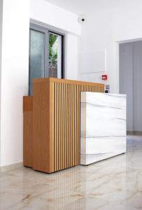 a wood and white reception desk in a room at Cottage Boutique Apartments Athens in Athens