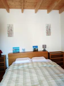 パンマールにあるMaison de 3 chambres a Penmarch a 500 m de la plage avec jardin clos et wifiのベッドルーム1室(ベッド1台付)が備わります。壁に2枚の写真が飾られています。