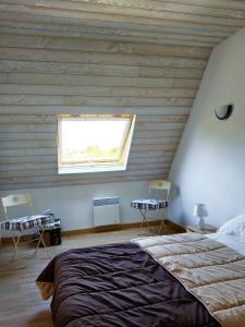 Un dormitorio con una cama grande y una ventana en Maison de 3 chambres a Penmarch a 500 m de la plage avec jardin clos et wifi, en Penmarch