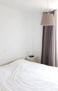 科克賽德－巴德的住宿－2 bedrooms apartement with balcony and wifi at Koksijde，卧室配有白色的床和灯