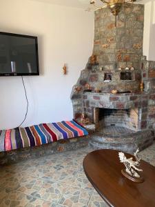 a living room with a stone fireplace and a tv at Mani Castle Houses in Mína