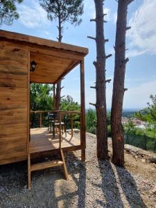 Cabaña de madera con mesa y sillas en una terraza en Sarı Konak Butik Otel en Gure