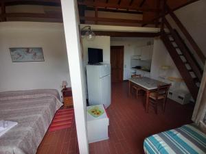 a room with a bed and a kitchen with a table at Podere S.Giulia - casale S.Giulia in Riotorto
