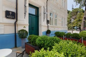 a green door on a building with potted plants at Boulevard Hotel Batumi in Batumi