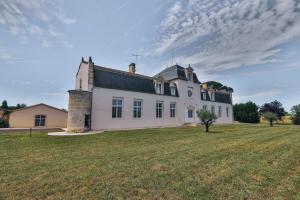 una gran casa blanca con un gran campo de césped en Domaine Grand Piquecaillou - Appartement Bordeaux, 