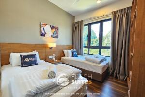 two beds in a hotel room with a window at Onsen Premium Suites @ Tambun Ipoh in Ipoh