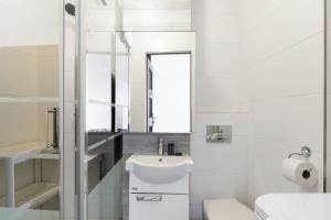 a white bathroom with a sink and a toilet at ShortStayPoland Madalińskiego (B130) in Warsaw