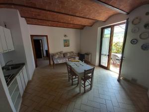 cocina y sala de estar con mesa y sillas en Podere S.Giulia - casale S.Giulia, en Riotorto