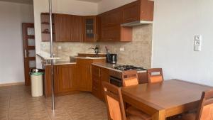 eine Küche mit Holzschränken und einem Holztisch mit einem Esszimmer in der Unterkunft Apartmán Třeboň in Třeboň