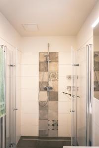 La salle de bains est pourvue d'une douche avec une porte en verre. dans l'établissement FEWO Wiesenschlummerland Harriersand, à Schwanewede