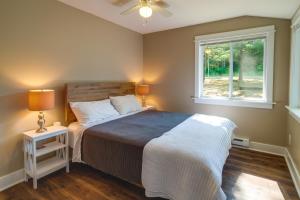 a bedroom with a large bed and a window at Pet-Friendly Kalkaska Cottage on Lake Crawford! in Kalkaska