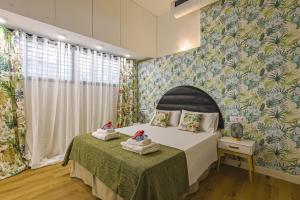 a bedroom with a bed and a wall with floral wallpaper at Alcam Les Corts in Barcelona