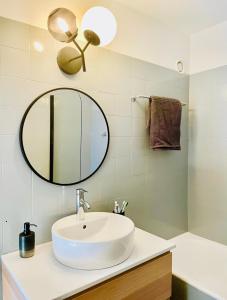 a bathroom with a white sink and a mirror at Window on Crans Montana, Appartement avec vue sur les Alpes in Crans-Montana