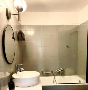 La salle de bains est pourvue d'un lavabo, d'un miroir et d'une baignoire. dans l'établissement Window on Crans Montana, Appartement avec vue sur les Alpes, à Crans-Montana