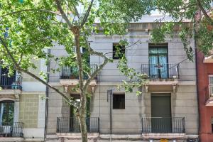 バルセロナにあるBBarcelona Sagrada Familia Terrace Flatのバルコニーと木があるアパートメントビル