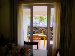 Cette chambre dispose d'une porte s'ouvrant sur une terrasse avec une table. dans l'établissement 3 bedrooms house with sea view shared pool and terrace at Palmar, à Palmar