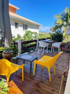 una terraza con sillas, mesas y una mesa en Studio avec terrasse amenagee et wifi a Le Vauclin a 3 km de la plage, en Le Vauclin