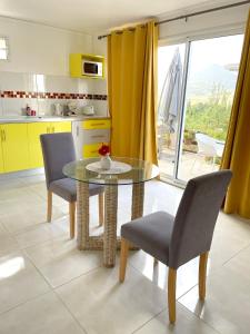 cocina con mesa de cristal y 2 sillas en Studio avec terrasse amenagee et wifi a Le Vauclin a 3 km de la plage, en Le Vauclin