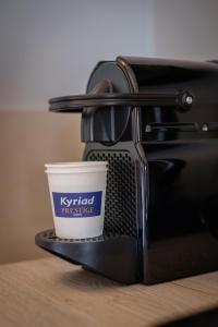filiżankę kawy siedzącą na topielcu w obiekcie Kyriad Prestige Lyon Est - Saint Priest Eurexpo Hotel and SPA w mieście Saint-Priest