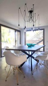a dining room with a table and white chairs at Charming Villa in El Vendrell + Pool in El Vendrell