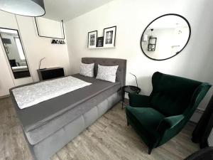 um quarto com uma cama, uma cadeira e um espelho em Schönes Appartement direkt am Wenigemarkt em Erfurt