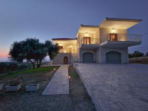 a large house with a walkway in front of it at Villa Oliveto con vista in Lefkada