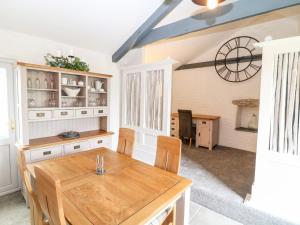 a kitchen with a wooden table and a clock on the wall at Polgear View in Redruth